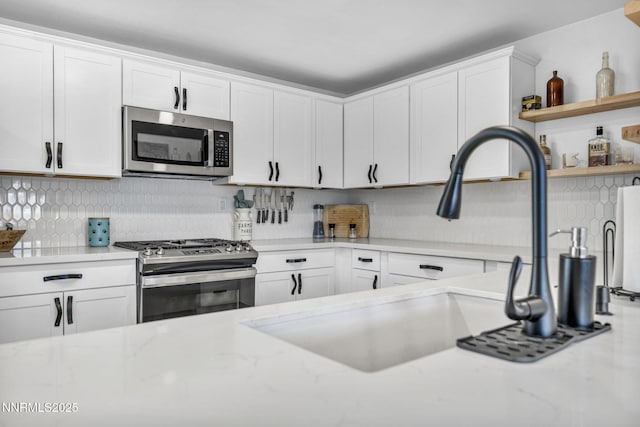 11471 Sitka St, Reno, NV 89506 - kitchen with appliances with stainless steel finishes, white cabinets, and tasteful backsplash