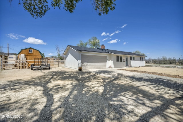 11471 Sitka St, Reno, NV 89506 - view of property exterior with a garage, a chimney, a barn, and an outdoor structure