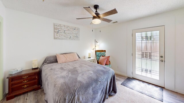 1615 Ballard Ln, Winnemucca, NV 89445 - bedroom featuring light wood-style floors, a textured ceiling, access to outside, and ceiling fan