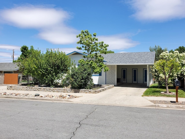 1615 Ballard Ln, Winnemucca, NV 89445 - view of front of property with concrete driveway, an attached carport, roof with shingles, and fence
