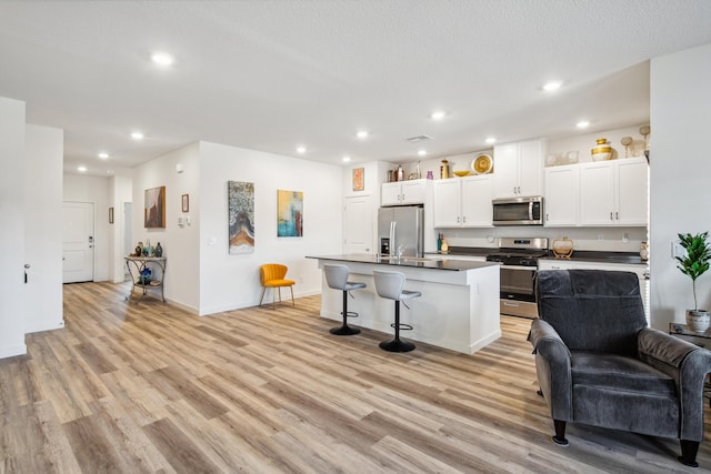 1733 Treeline Dr, Fernley, NV 89408 - kitchen featuring stainless steel appliances, open floor plan, light wood finished floors, white cabinets, and recessed lighting