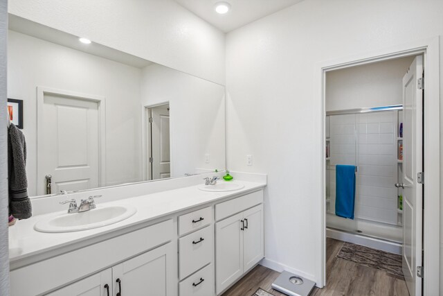 1733 Treeline Dr, Fernley, NV 89408 - full bathroom with wood finished floors, double vanity, a tile shower, and baseboards