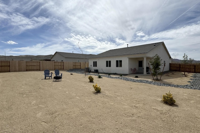 1733 Treeline Dr, Fernley, NV 89408 - rear view of house with a fenced backyard, a patio, a fire pit, and stucco siding
