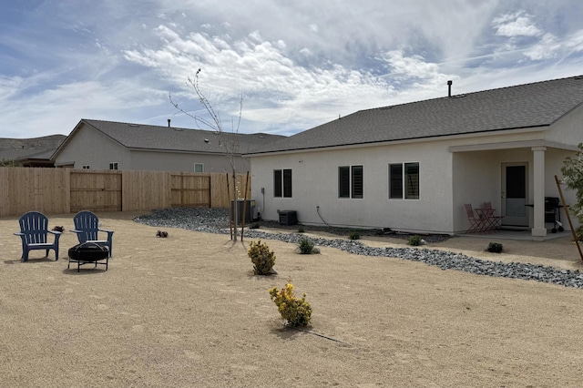 1733 Treeline Dr, Fernley, NV 89408 - rear view of house featuring an outdoor fire pit, stucco siding, a shingled roof, and central air condition unit