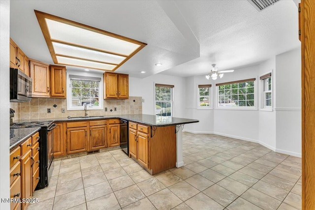 3277 Dartmouth Ct, Carson City, NV 89703 - kitchen with black appliances, a peninsula, a sink, backsplash, and brown cabinets