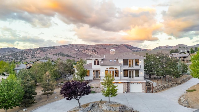 17144 Majestic View Dr, Reno, NV 89521 - view of front of house with driveway, a mountain view, a chimney, a garage, and stucco siding