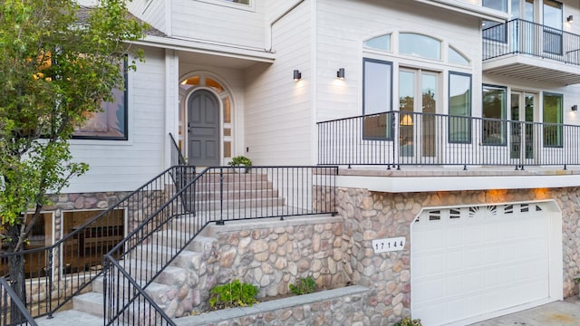 17144 Majestic View Dr, Reno, NV 89521 - property entrance with stone siding, an attached garage, and a balcony