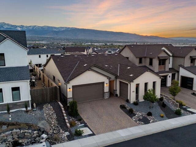 15025 Iron River Dr, Reno, NV 89521 - view of front of property featuring a garage, a mountain view, stucco siding, a residential view, and decorative driveway