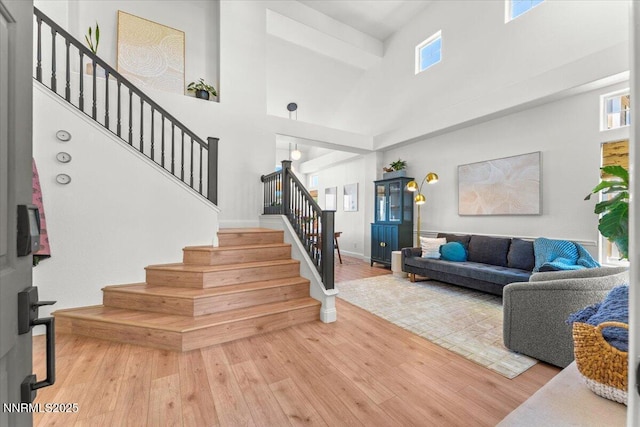 5540 Twin Creeks Dr, Reno, NV 89523 - staircase featuring wood finished floors, a towering ceiling, and baseboards