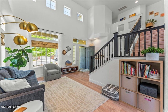 5540 Twin Creeks Dr, Reno, NV 89523 - living area featuring stairway, healthy amount of natural light, wood finished floors, baseboards, and a towering ceiling