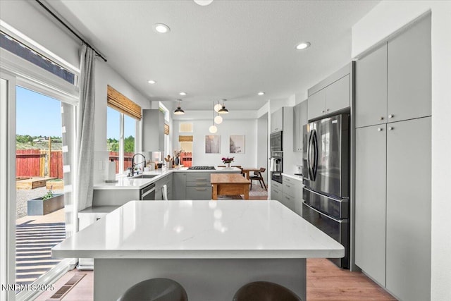 5540 Twin Creeks Dr, Reno, NV 89523 - kitchen featuring gray cabinets, stainless steel appliances, a kitchen bar, recessed lighting, and a center island