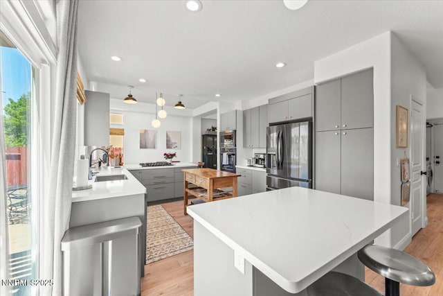 5540 Twin Creeks Dr, Reno, NV 89523 - kitchen featuring gray cabinets, a sink, appliances with stainless steel finishes, light countertops, and light wood-type flooring