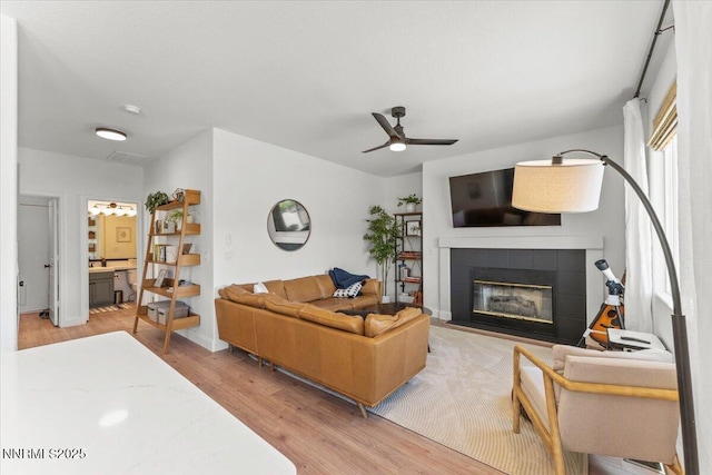 5540 Twin Creeks Dr, Reno, NV 89523 - living area featuring a tile fireplace, light wood-type flooring, and a ceiling fan