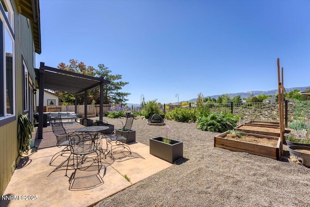 5540 Twin Creeks Dr, Reno, NV 89523 - fenced backyard featuring a vegetable garden, a patio, an outdoor living space with a fire pit, and a mountain view
