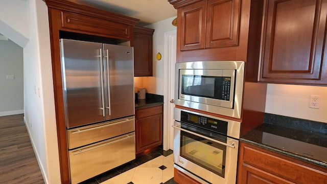 200 W 2nd St Apt 707, Reno, NV 89501 - kitchen with appliances with stainless steel finishes, dark stone counters, arched walkways, and baseboards
