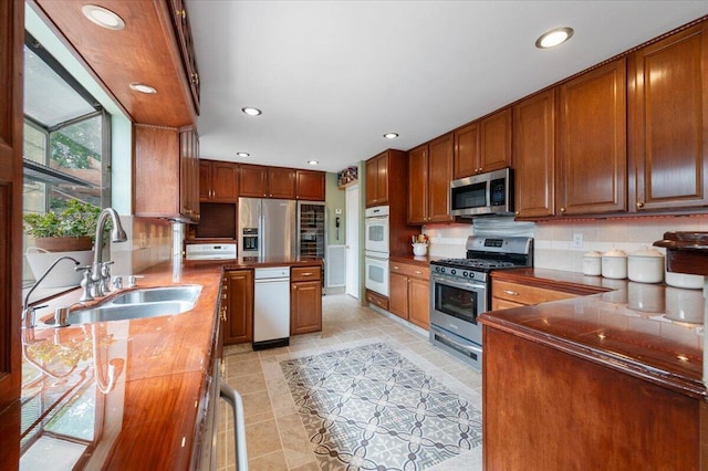 410 Pheasant Dr, Fallon, NV 89406 - kitchen with appliances with stainless steel finishes, a sink, backsplash, recessed lighting, and light tile patterned floors