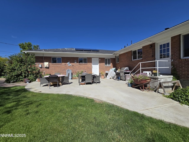 1290 Westwood Dr, Reno, NV 89509 - rear view of property featuring a patio area, solar panels, a yard, and brick siding