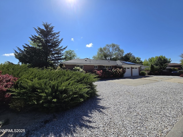 1290 Westwood Dr, Reno, NV 89509 - ranch-style house with an attached garage, driveway, and roof mounted solar panels