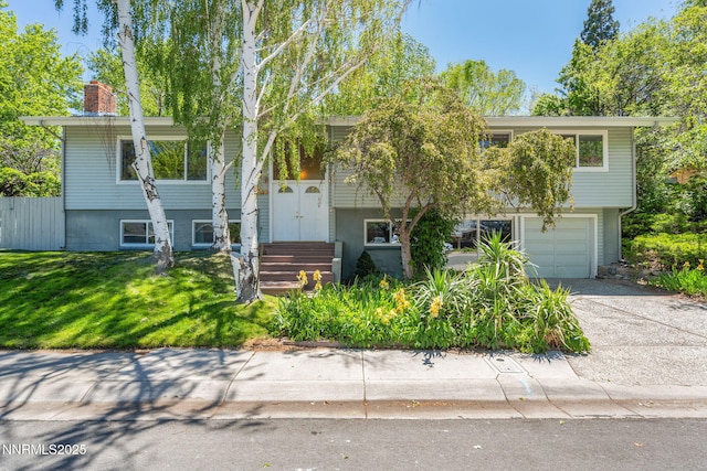 2770 Solari Dr, Reno, NV 89509 - split foyer home featuring driveway, a garage, and a chimney