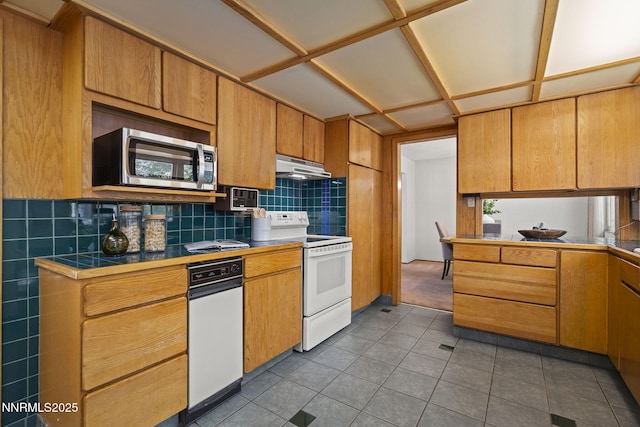 2770 Solari Dr, Reno, NV 89509 - kitchen featuring electric range, stainless steel microwave, tile counters, decorative backsplash, and dark tile patterned floors