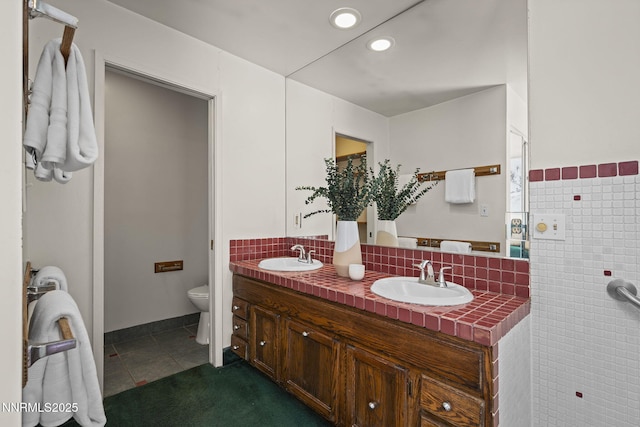 2770 Solari Dr, Reno, NV 89509 - bathroom with double vanity, toilet, tile patterned floors, recessed lighting, and decorative backsplash