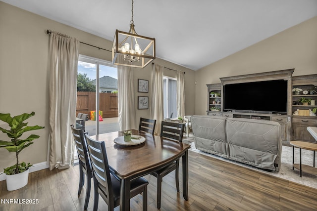7442 Celeste Dr, Reno, NV 89511 - dining space with a chandelier, wood finished floors, vaulted ceiling, and baseboards