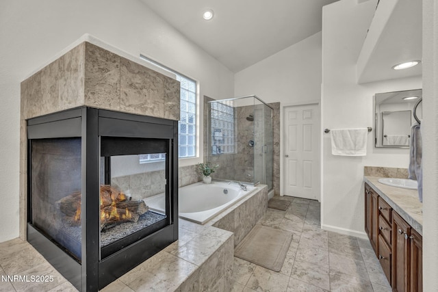 7442 Celeste Dr, Reno, NV 89511 - full bathroom featuring a multi sided fireplace, a shower stall, a garden tub, vanity, and baseboards