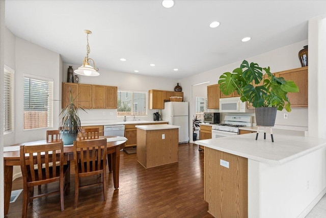 5625 Spandrell Cir, Sparks, NV 89436 - kitchen featuring white appliances, a sink, dark wood-style floors, light countertops, and a center island