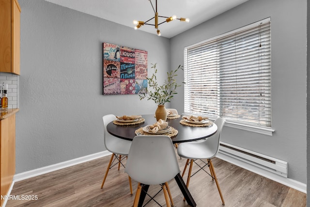 3951 Clear Acre Ln Unit 293, Reno, NV 89512 - dining area featuring a baseboard heating unit, a chandelier, wood finished floors, plenty of natural light, and a textured wall