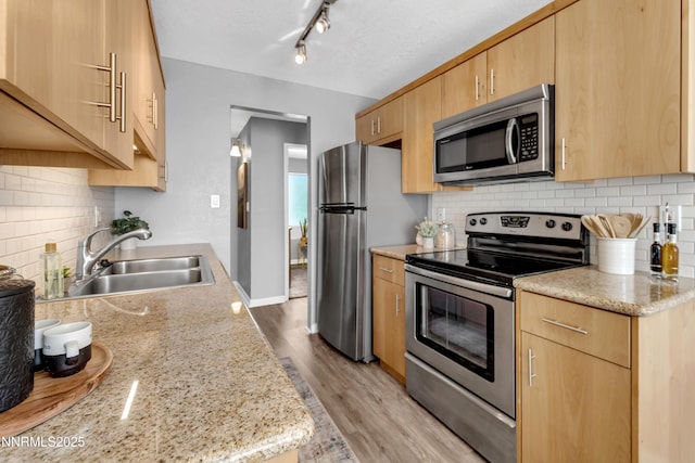 3951 Clear Acre Ln Unit 293, Reno, NV 89512 - kitchen with stainless steel appliances, a sink, light brown cabinetry, light wood-style floors, and decorative backsplash