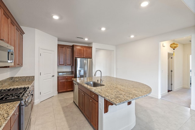 7480 Souverain Ln, Reno, NV 89506 - kitchen featuring stainless steel appliances, a sink, a kitchen island with sink, light stone countertops, and recessed lighting