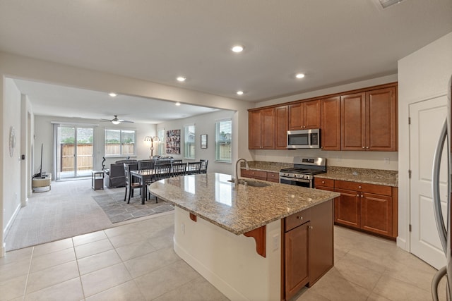 7480 Souverain Ln, Reno, NV 89506 - kitchen with appliances with stainless steel finishes, a sink, light stone countertops, a center island with sink, and recessed lighting