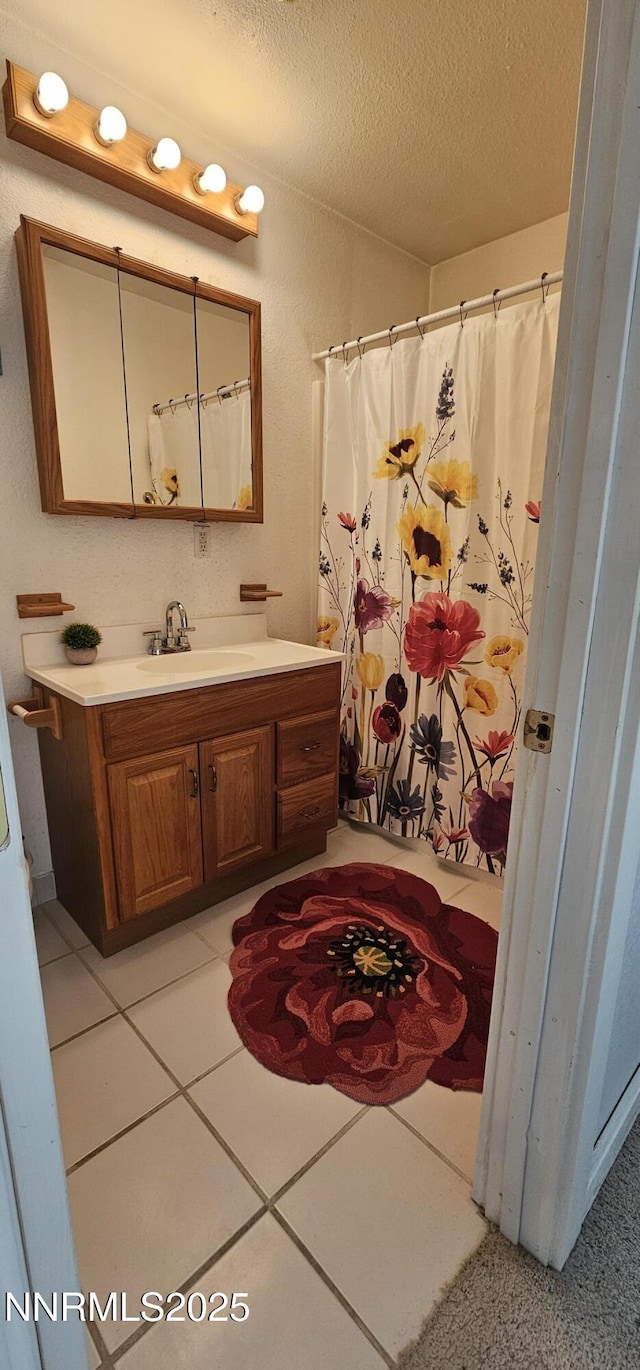 155 James Ct, Kingston, NV 89310 - full bathroom featuring a textured ceiling, vanity, tile patterned floors, and a shower with shower curtain