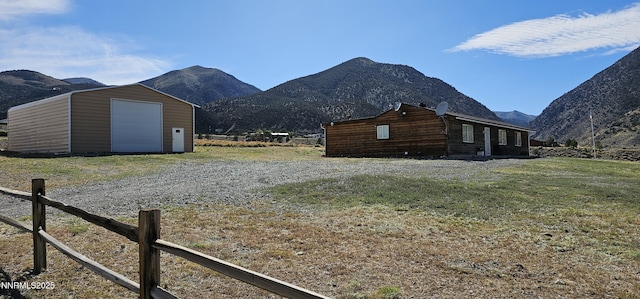 155 James Ct, Kingston, NV 89310 - view of home's exterior with a mountain view, an outdoor structure, gravel driveway, and a detached garage