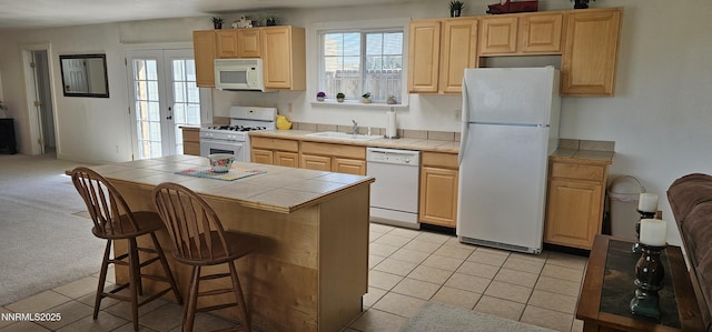 155 James Ct, Kingston, NV 89310 - kitchen with white appliances, tile counters, a sink, light brown cabinets, and a center island