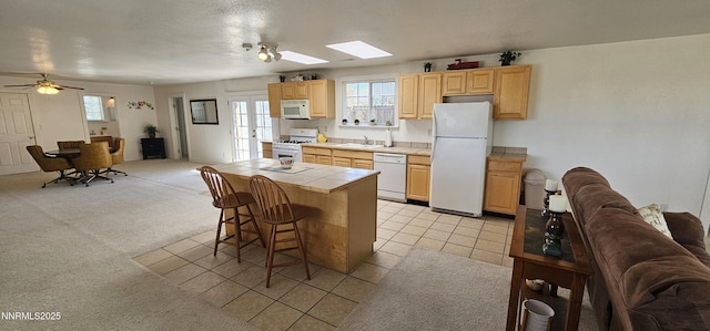 155 James Ct, Kingston, NV 89310 - kitchen with white appliances, tile countertops, open floor plan, a skylight, and light brown cabinets