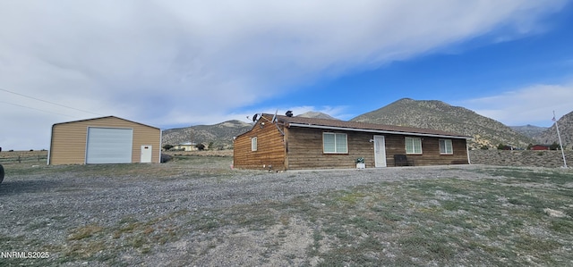 155 James Ct, Kingston, NV 89310 - rear view of property featuring a mountain view, an outbuilding, a detached garage, and gravel driveway