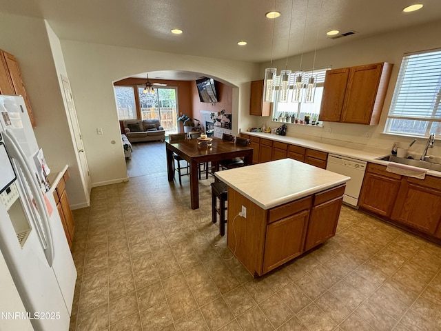 1224 Mountain Rose Dr, Fernley, NV 89408 - kitchen with white appliances, arched walkways, a sink, brown cabinets, and recessed lighting
