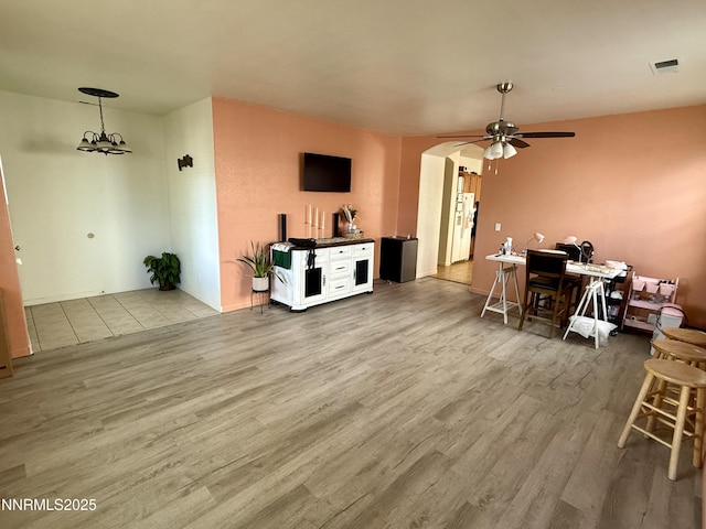 1224 Mountain Rose Dr, Fernley, NV 89408 - living room with wood finished floors, arched walkways, a ceiling fan, and a chandelier