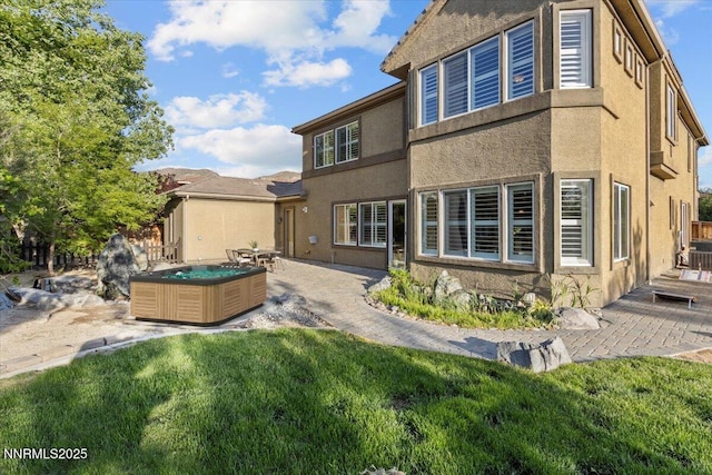 2675 Weymoor Ct, Reno, NV 89521 - back of house featuring a patio, a yard, stucco siding, and a hot tub