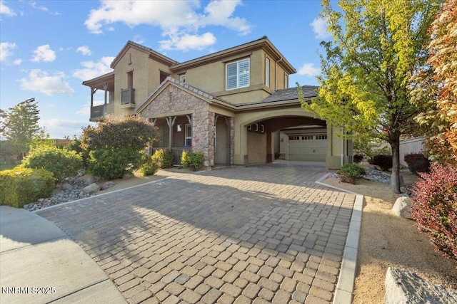 2675 Weymoor Ct, Reno, NV 89521 - view of front facade with stucco siding, decorative driveway, stone siding, covered porch, and an attached garage
