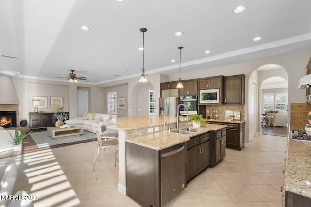 2675 Weymoor Ct, Reno, NV 89521 - kitchen with arched walkways, appliances with stainless steel finishes, a sink, open floor plan, and decorative backsplash