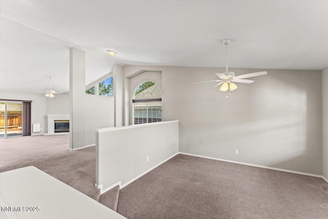 4515 Vista Mountain Dr, Sparks, NV 89436 - carpeted empty room featuring ceiling fan, lofted ceiling, plenty of natural light, a glass covered fireplace, and baseboards