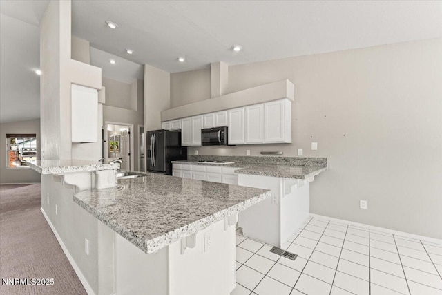 4515 Vista Mountain Dr, Sparks, NV 89436 - kitchen with black appliances, a peninsula, a breakfast bar, a sink, and white cabinets
