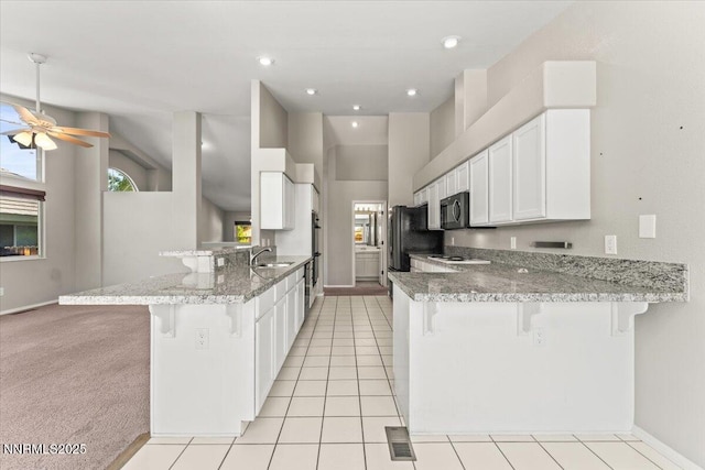4515 Vista Mountain Dr, Sparks, NV 89436 - kitchen with a peninsula, a sink, a breakfast bar, black appliances, and recessed lighting
