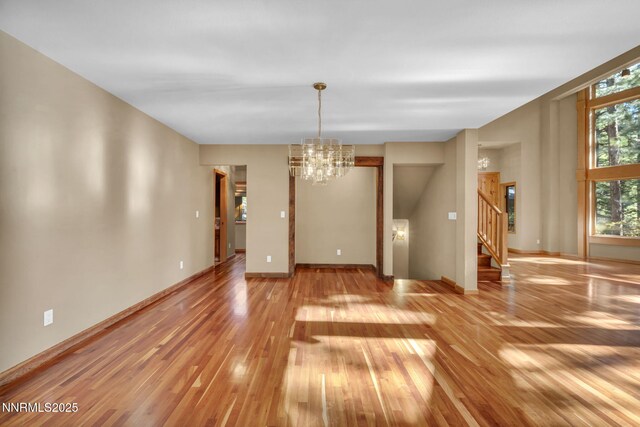 1445 Austrian Pine Rd, Reno, NV 89511 - empty room featuring a chandelier, light wood-type flooring, stairway, and baseboards