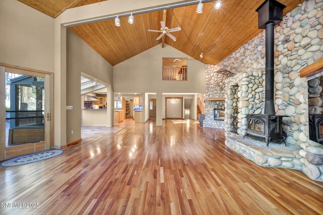 1445 Austrian Pine Rd, Reno, NV 89511 - unfurnished living room with a wood stove, hardwood / wood-style flooring, track lighting, high vaulted ceiling, and wood ceiling