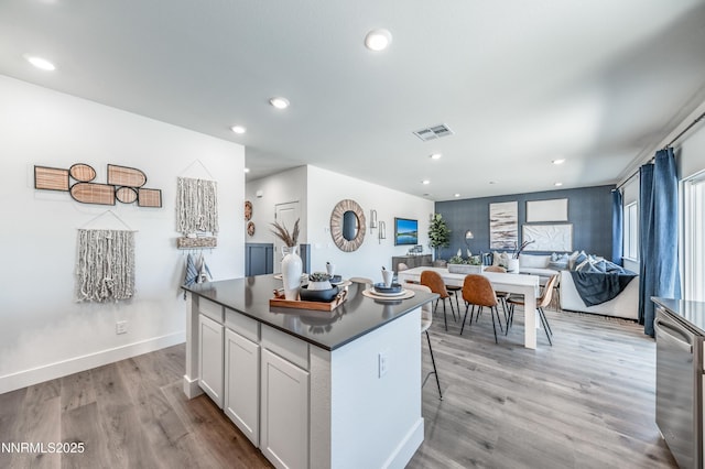 7609 Apex Pl # 113, Reno, NV 89506 - kitchen featuring dark countertops, a center island, light wood-style floors, white cabinets, and recessed lighting