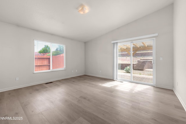 17330 Desert Lake Dr, Reno, NV 89508 - spare room with plenty of natural light, light wood-type flooring, vaulted ceiling, and baseboards
