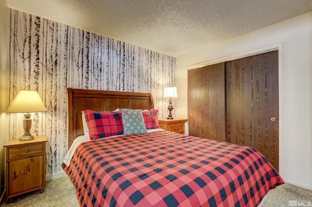 758 Milky Way Ct Unit B, Stateline, NV 89449 - bedroom featuring carpet flooring, a closet, a textured ceiling, wallpapered walls, and baseboards